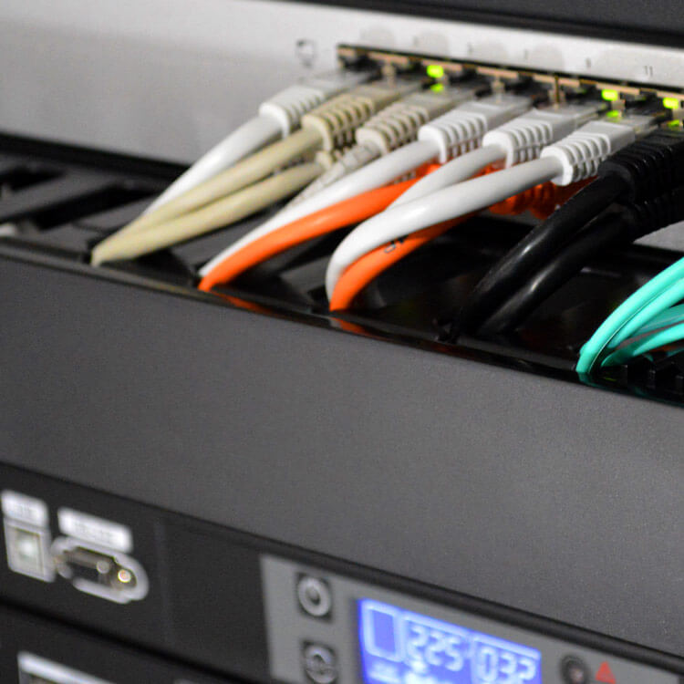 nätverkskablar anslutna till serverutrustning i rackskåp för tydlig kabelorganisation